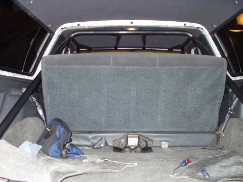 1993 Ford Bronco - The interior of a vehicle shows a rear seat and a prominent roll cage structure.