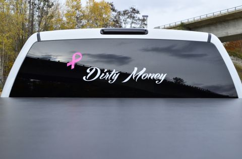 2006 Chevrolet Silverado 2500 - Rear window decal on a truck features a pink ribbon and the words 'Dirty Money'.