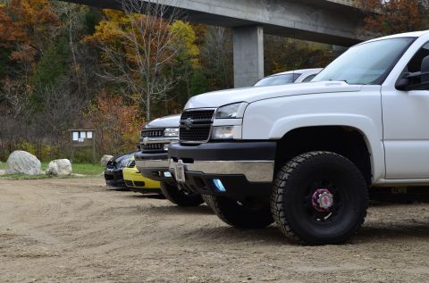 2006 Chevrolet Silverado 2500 - A white 2006 Chevrolet Silverado 2500 pickup truck is parked in a line with other vehicles under a bridge.