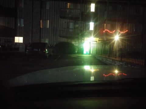 2000 Mercury Grand Marquis - Car parked outside an apartment building at night, with lights on inside and festive lights on the exterior.