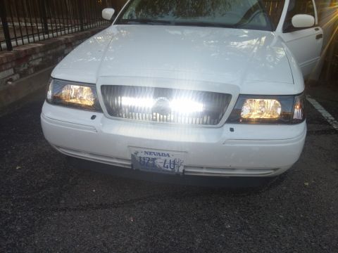 2000 Mercury Grand Marquis - Front view of a white 2000 Mercury Grand Marquis, showing its grille and headlights.