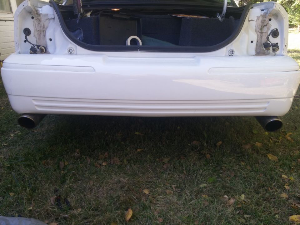 White 2000 Mercury Grand Marquis rear bumper with dual exhaust pipes