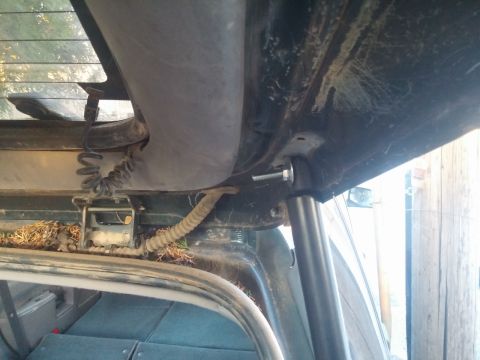 2000 Mercury Grand Marquis - Detail of a rear hatch strut mount, showing the attachment point and surrounding interior components.