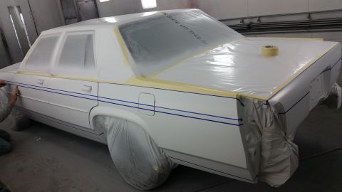 1991 Ford LTD Crown Victoria - Car in paint booth, covered for prep work, showing blue pinstripes on the rear quarter panel.