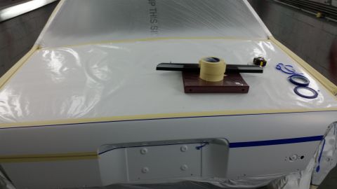 1991 Ford LTD Crown Victoria - A car's trunk is prepared for painting with plastic sheeting and various taping supplies.