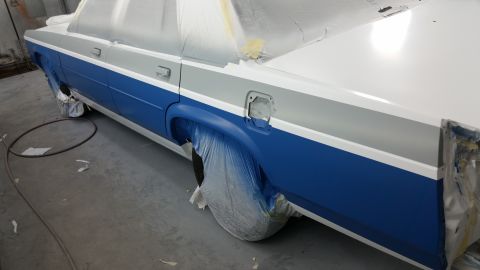 1991 Ford LTD Crown Victoria - A car is being prepped for painting, with blue and grey sections visible under protective coverings.