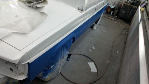 1991 Ford LTD Crown Victoria - A car body is being prepped for painting in a workshop environment.