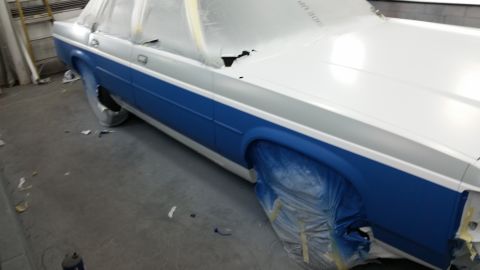 1991 Ford LTD Crown Victoria - Side view of a 1991 Ford Crown Victoria LTD in a paint shop, covered in protective plastic.