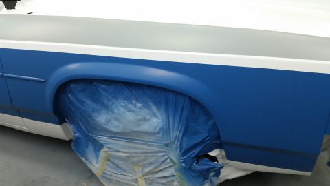 1991 Ford LTD Crown Victoria - A car fender is covered in blue plastic sheeting, preparing for a paint job.