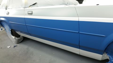 1991 Ford LTD Crown Victoria - A car's side panel, a two-tone blue and white paint scheme, is shown during a painting process.