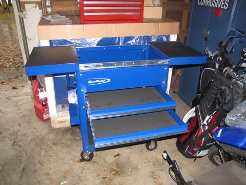 1992 Ford F-150 - A blue rolling tool cart is shown next to a golf bag and other items in a garage.