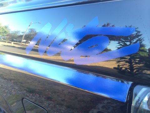 1992 Ford Bronco - Close-up of a blue 'Nite' decal on the side of a dark-colored vehicle.