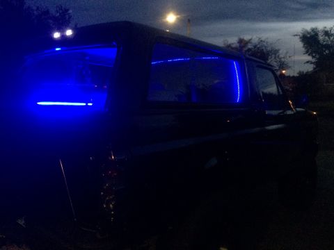 1992 Ford Bronco - A 1992 Ford Bronco is illuminated by blue LED lights inside its cabin at dusk.