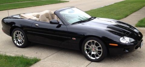 1998 Ford Crown Victoria - This black convertible sports car has a tan interior and chrome wheels.