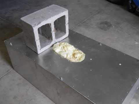 1992 Ford Bronco - A cinder block is placed on a metal container with some expanding foam nearby.