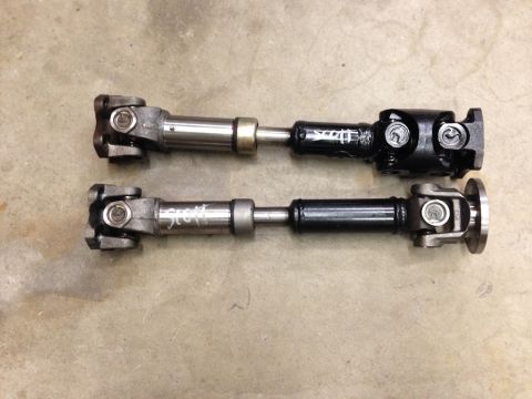 1987 Suzuki Samurai - Two drive shafts are shown on a concrete surface, with visible writing on each.