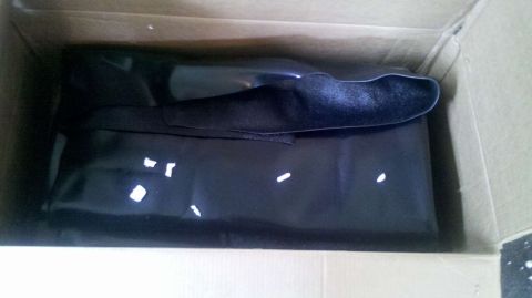 1982 Ford Bronco - A black car cover is shown folded inside a cardboard box, with a website logo visible.