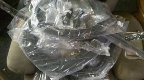1982 Ford Bronco - Unidentified automotive parts are bundled together in plastic packaging.