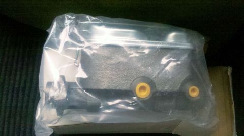 1982 Ford Bronco - A close-up view of an automotive part, likely a brake caliper, sealed in plastic packaging.