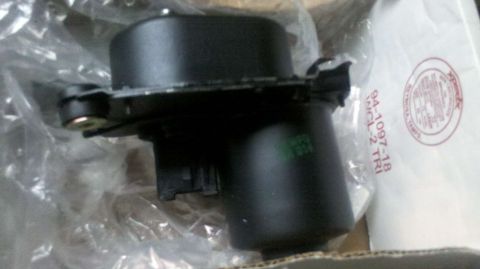 1982 Ford Bronco - A black automotive part is shown in its packaging, with part numbers visible on an accompanying bag.