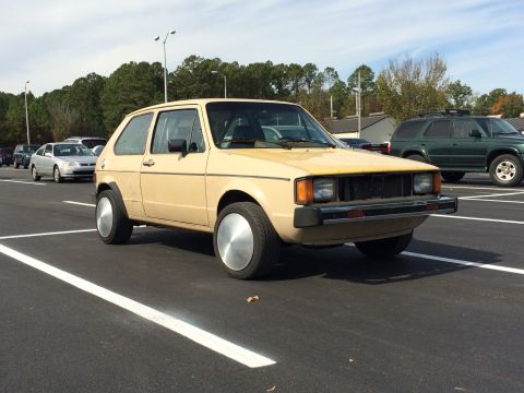 1983 Volkswagen Rabbit - This 1983 Volkswagen Rabbit features distinctive large silver hubcaps and a tan exterior.