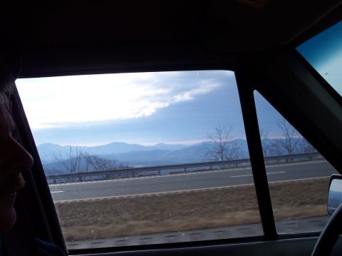 1990 Ford Bronco - Driving through a mountainous region with a cloudy sky overhead.