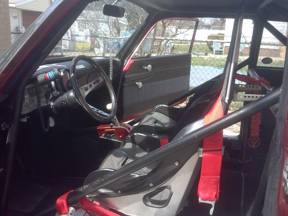 Interior view of a race car with roll cage, racing seats, and custom gauges