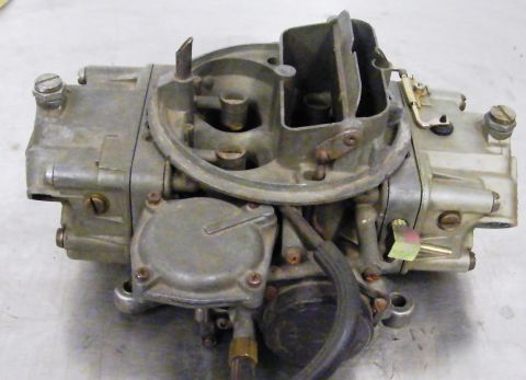1968 Mercury Cougar - A close-up view of a carburetor, identified by the "SUPERMOTORS" text on the lower right.