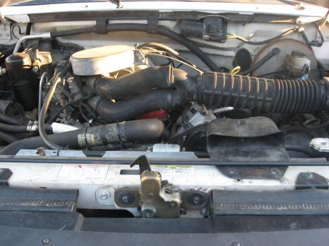 1994 Ford Bronco - Close-up view of the engine compartment, showing various hoses and the air intake system.