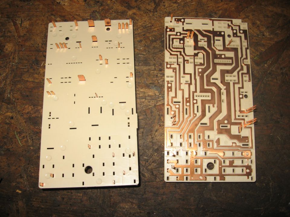 Two circuit boards, one with copper traces, on a wooden surface