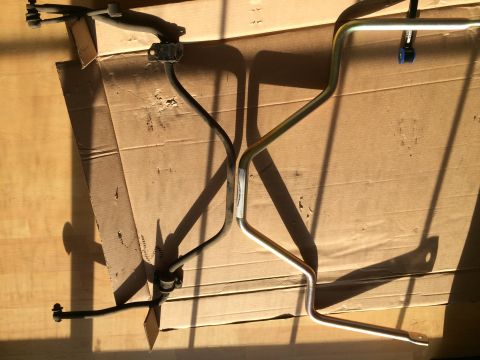 1997 Dodge 3500 - Two sway bars are shown, one black and one silver, resting on a cardboard surface.