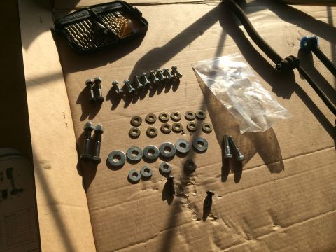 1997 Dodge 3500 - Hardware and parts for a sway bar installation are organized on a cardboard surface.