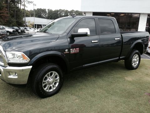 1989 Ford Bronco - Black Ram 2500 pickup truck with chrome accents and alloy wheels.