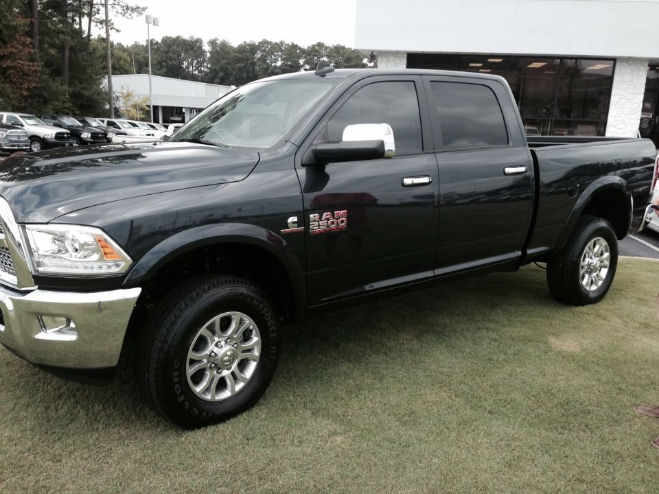 Black Ram 2500 pickup truck parked on grass, front quarter view