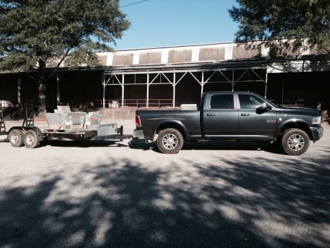 1989 Ford Bronco - A dark gray pickup truck is seen from the side, towing a utility trailer. The truck appears to be from the 2010s.