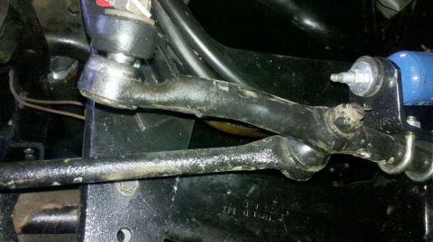 1982 Ford Bronco - Undercarriage view of suspension components, including tie rods and ball joints, with a blue shock absorber visible.