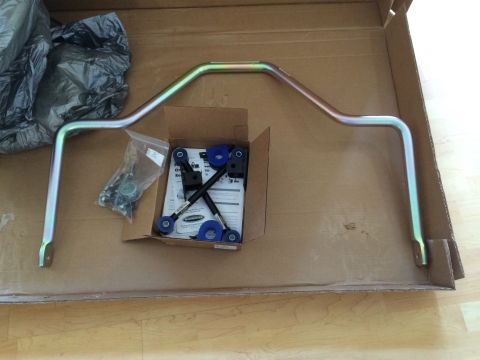1997 Dodge 3500 - A sway bar kit, including a metal bar and blue bushings, is laid out in a cardboard box.