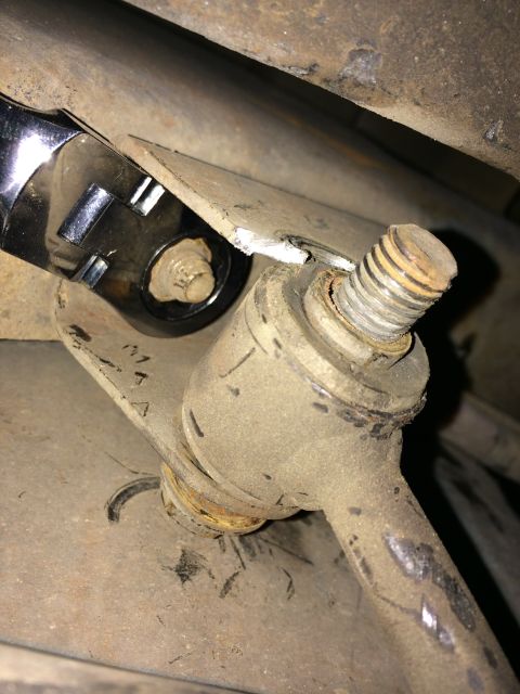 1997 Dodge 3500 - A socket wrench is used to adjust a sway bar link on a vehicle's undercarriage.