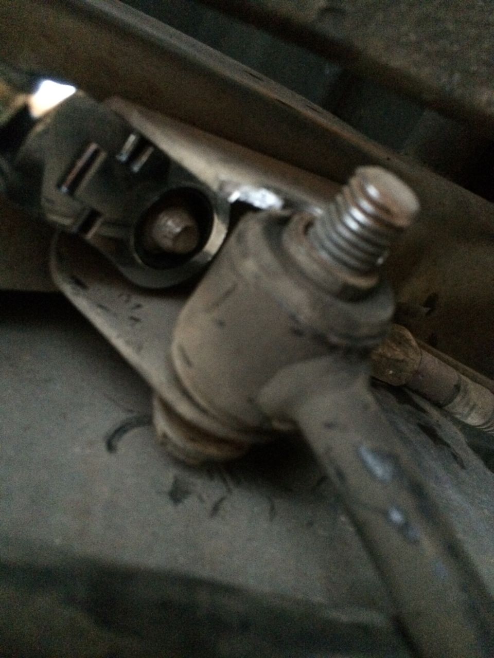 Close-up of a sway bar end link connection with a bolt and threaded rod
