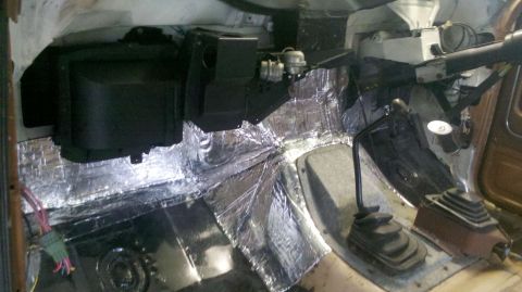 1982 Ford Bronco - The interior of a vehicle is shown with sound deadening material applied to the floor and lower dashboard area.