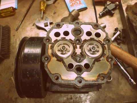 1964 Mercury Monterey - Close-up of a disassembled automotive part, likely a pump or compressor, with tools scattered around.