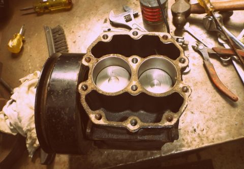 1964 Mercury Monterey - Close-up of an engine block's cylinder head, showing two cylinders and pistons, with various tools scattered around.