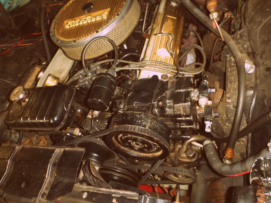 Engine bay detail showing air cleaner, belts, and engine block