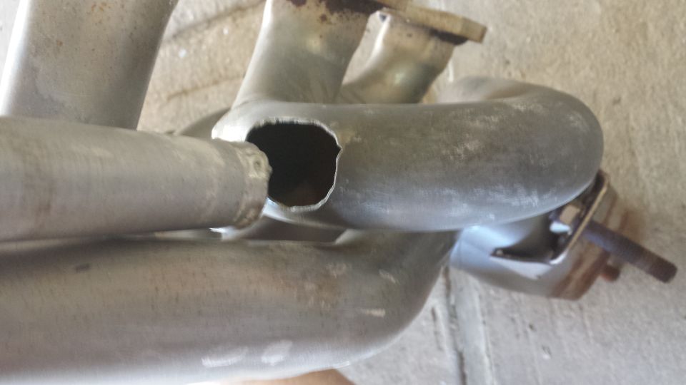 exhaust manifold with a hole in it, shows supermotors.net logo