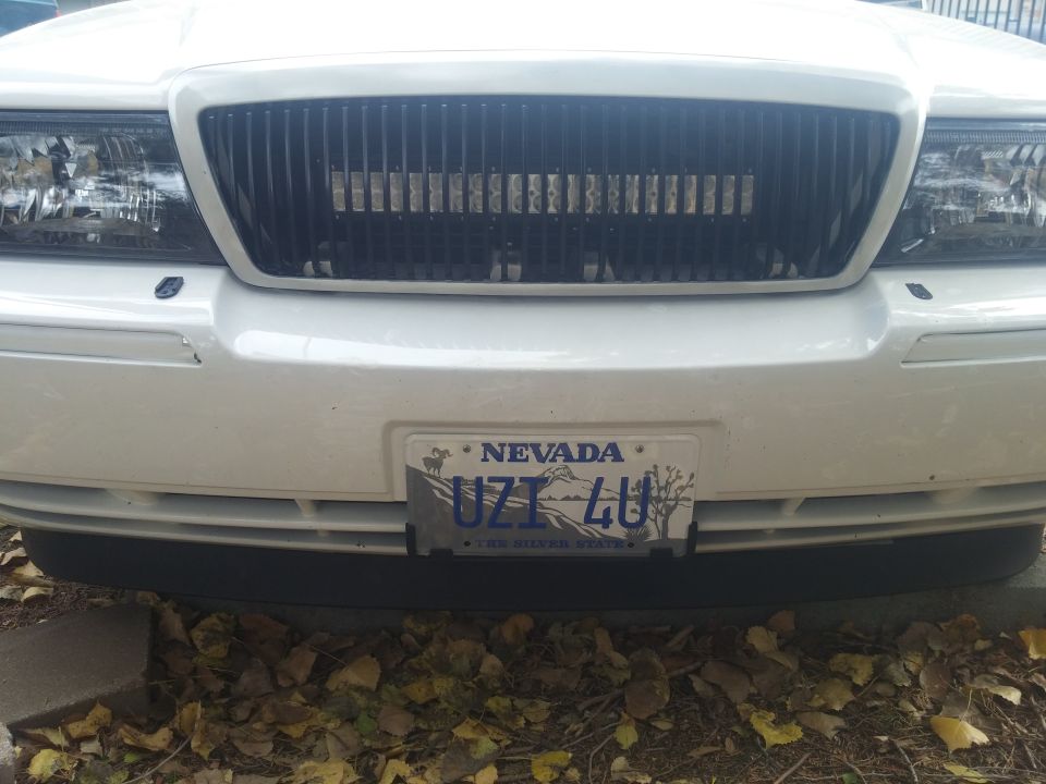 White 2000 Mercury Grand Marquis front grille with vertical bars and an LED light bar, Nevada license plate UZT 4U