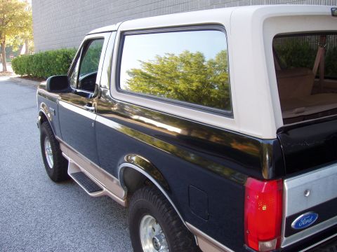 1996 Ford Bronco - This Ford Bronco, viewed from the rear three-quarter angle, displays its two-tone paint scheme and side steps.