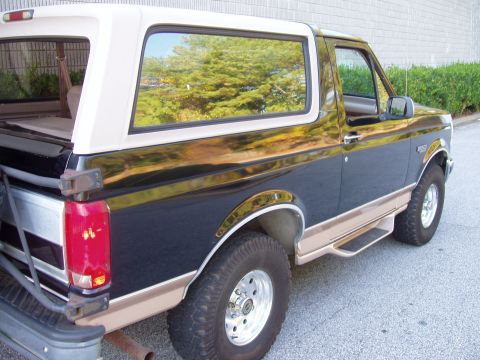 1996 Ford Bronco - Side view of a 1996 Ford Bronco with a two-tone paint scheme and removable top.