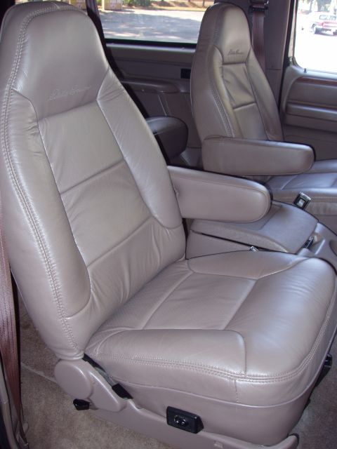 1996 Ford Bronco - Interior view of tan leather captain's chairs with armrests in a 1996 Ford Bronco.