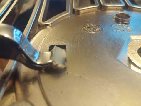 2000 Mercury Grand Marquis - A close-up view of a vehicle's wheel cover, showing some of its details and a small ring resting on its surface.