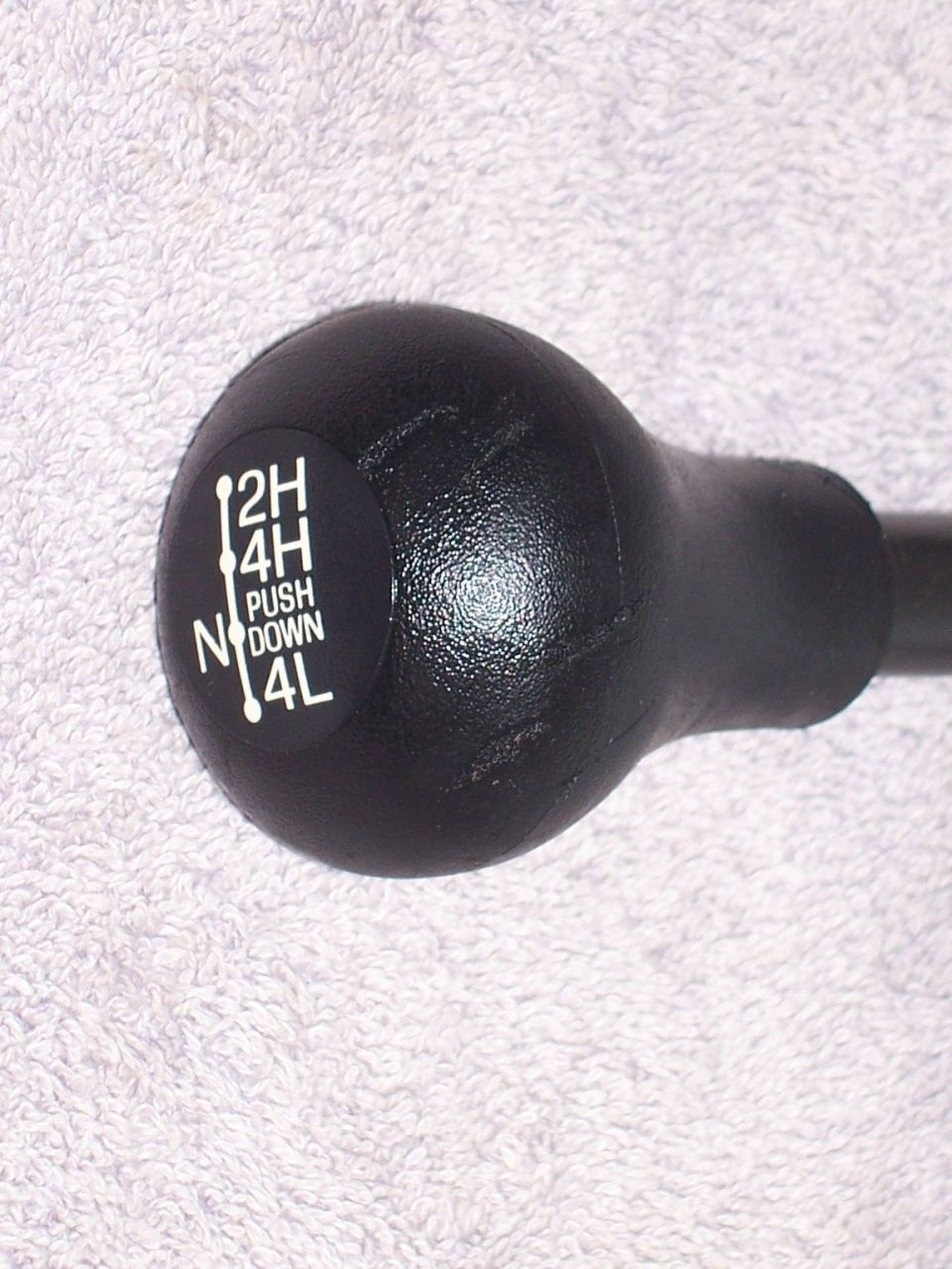 Black transfer case shifter knob with white text indicating 2H, 4H, N, 4L, and PUSH DOWN